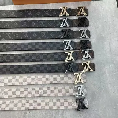 Row of monogram canvas belts with silver initial buckles