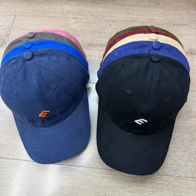 Baseball caps in navy, black and pastel colours stacked together