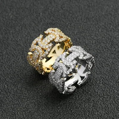 Two iced-out rings in gold and silver tone on a dark surface